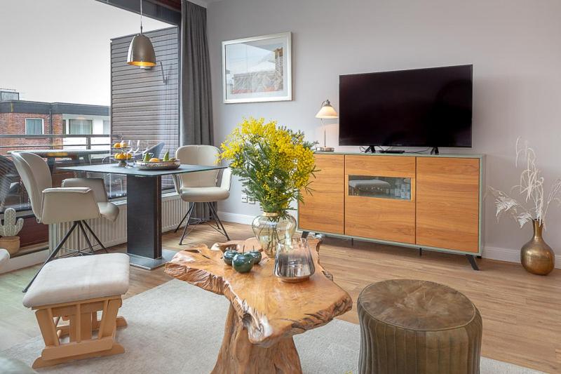 a living room with a television and a table with chairs at F35B 18 Seaside 18 in Westerland (Sylt)