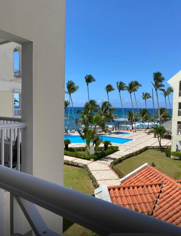 a view of the pool from the balcony of a resort at Albatros Cozy Apt in Juan Dolio