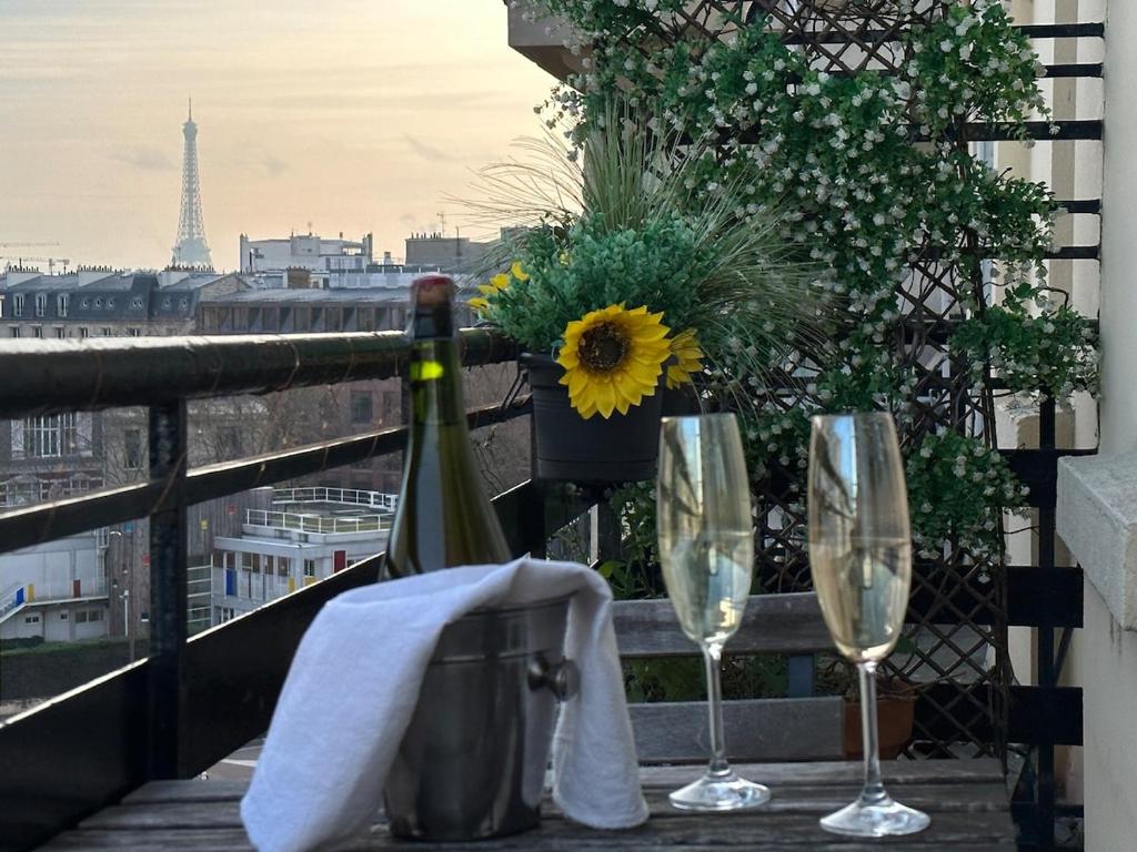 - une table avec une bouteille de vin et 2 verres à vin dans l'établissement Eiffel Tower view Arc Triomphe Champs Elysées area, à Paris