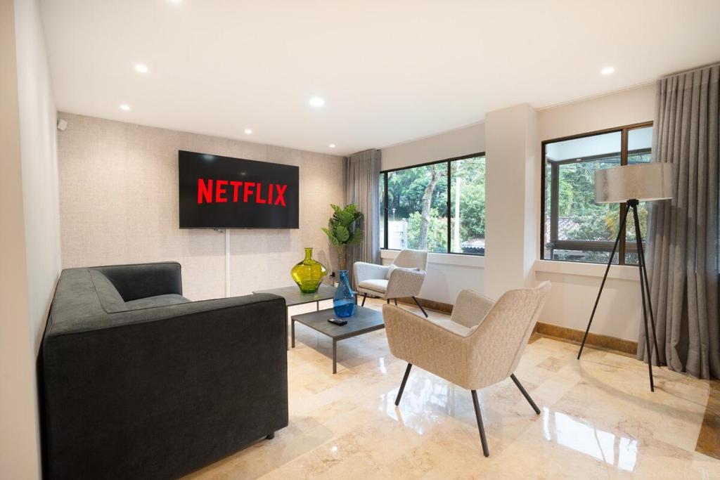 a living room with a couch and some chairs at Provenza Lux Apartment l Guest Friendly l Fast Wifi l 9 Guest in Medellín