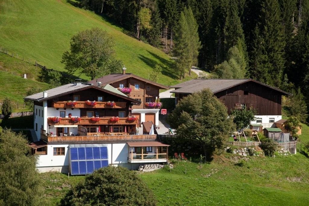 ein Haus auf einem Hügel mit einem Sonnenkollektor darauf in der Unterkunft Berggasthof-Ferienbauernhof Habersatt in Altenmarkt im Pongau