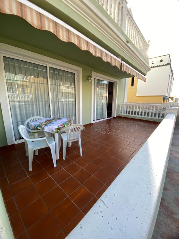 a screened in porch with a table and chairs at Atardecer Azul in Puerto Naos