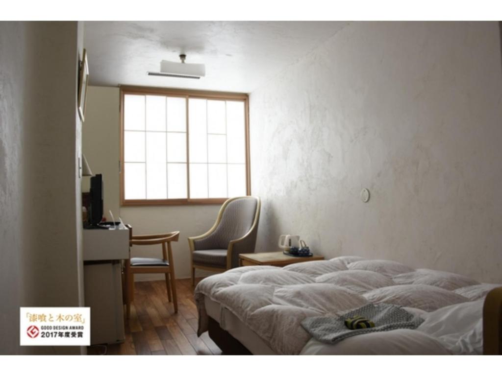 a bedroom with a bed and a desk and a window at Ryokan Akebono - Vacation STAY 21216v in Saga