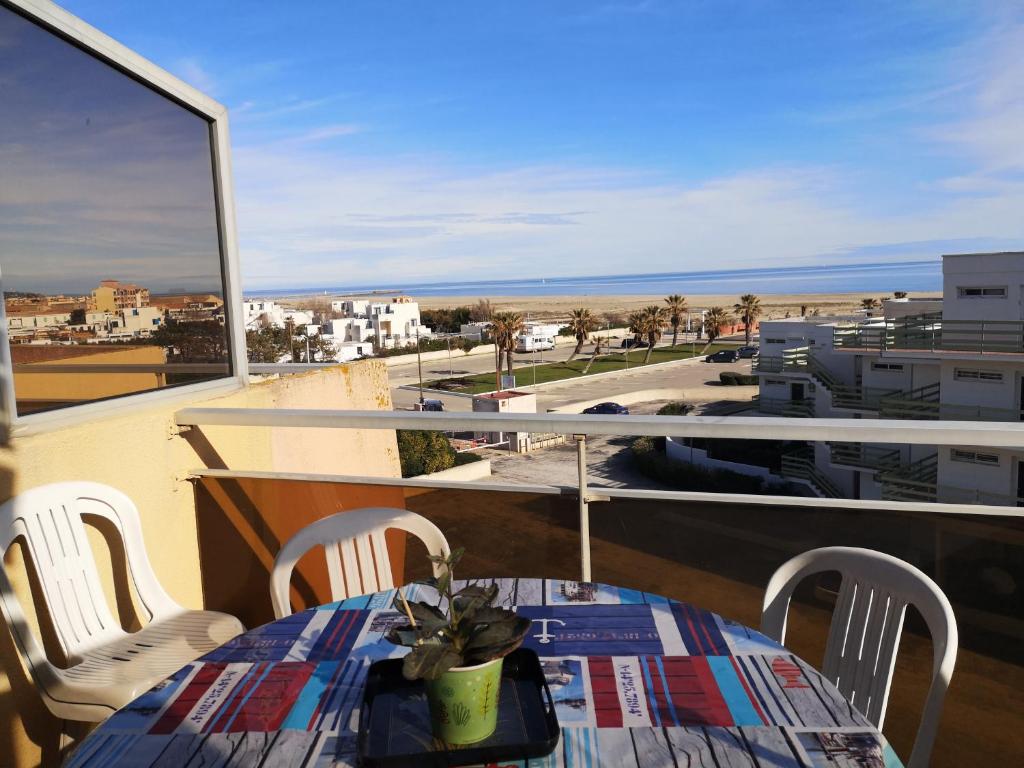 un balcon avec une table et des chaises et une vue sur l'océan dans l'établissement Bel Appartement Terrasse Vue Mer, à Port-Leucate