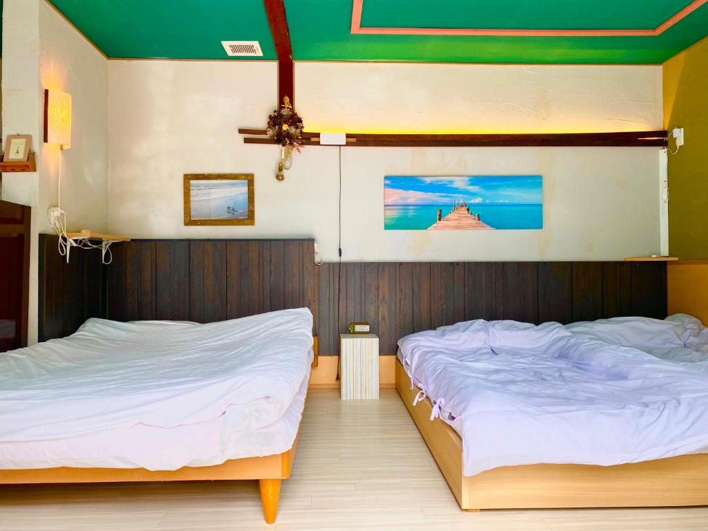 two twin beds in a room withthritisthritisthritisthritisthritisthritisthritisthritisthritis at Hyuga Surf Camp106 - Vacation STAY 29716v in Hyuga
