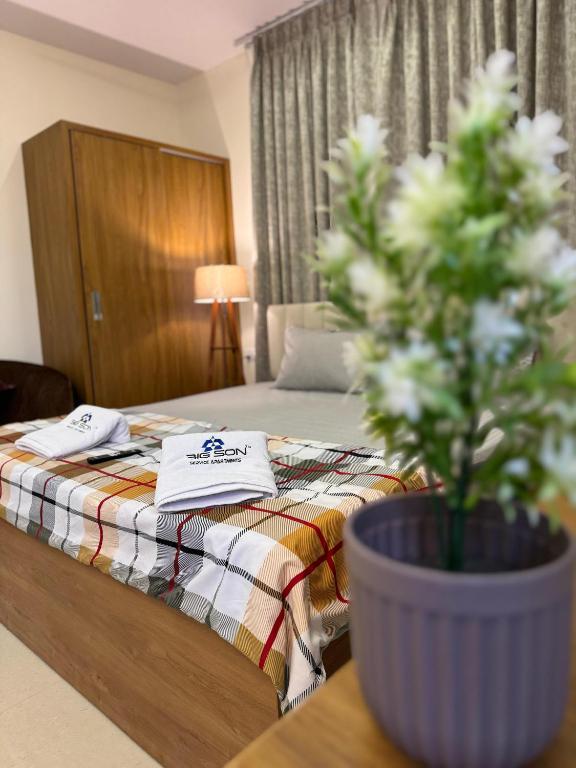 a bedroom with a bed and a potted plant on a table at Bigson Blissful Studios in Hyderabad
