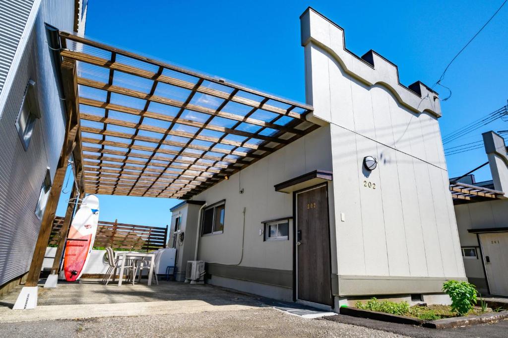 une pergola sur le côté d'un bâtiment dans l'établissement Hyuga Surf Camp202 - Vacation STAY 31884v, à Hyuga