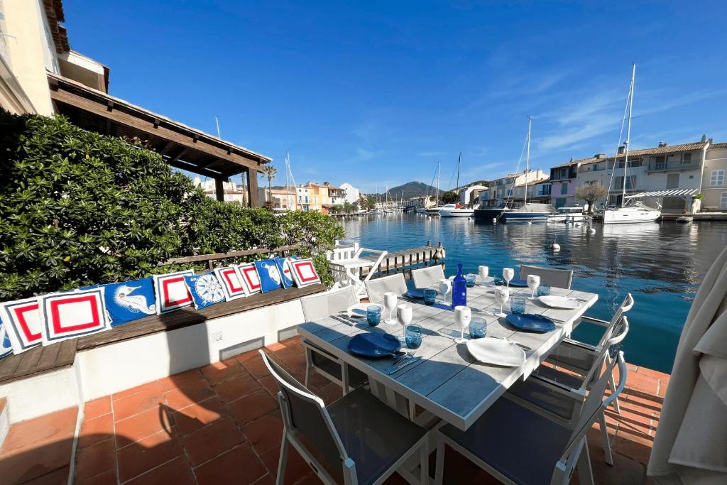 une table et des chaises assises sur une terrasse au bord de l'eau dans l'établissement Fisherman house - 16m-mooring and a wonderful panoramic, à Grimaud