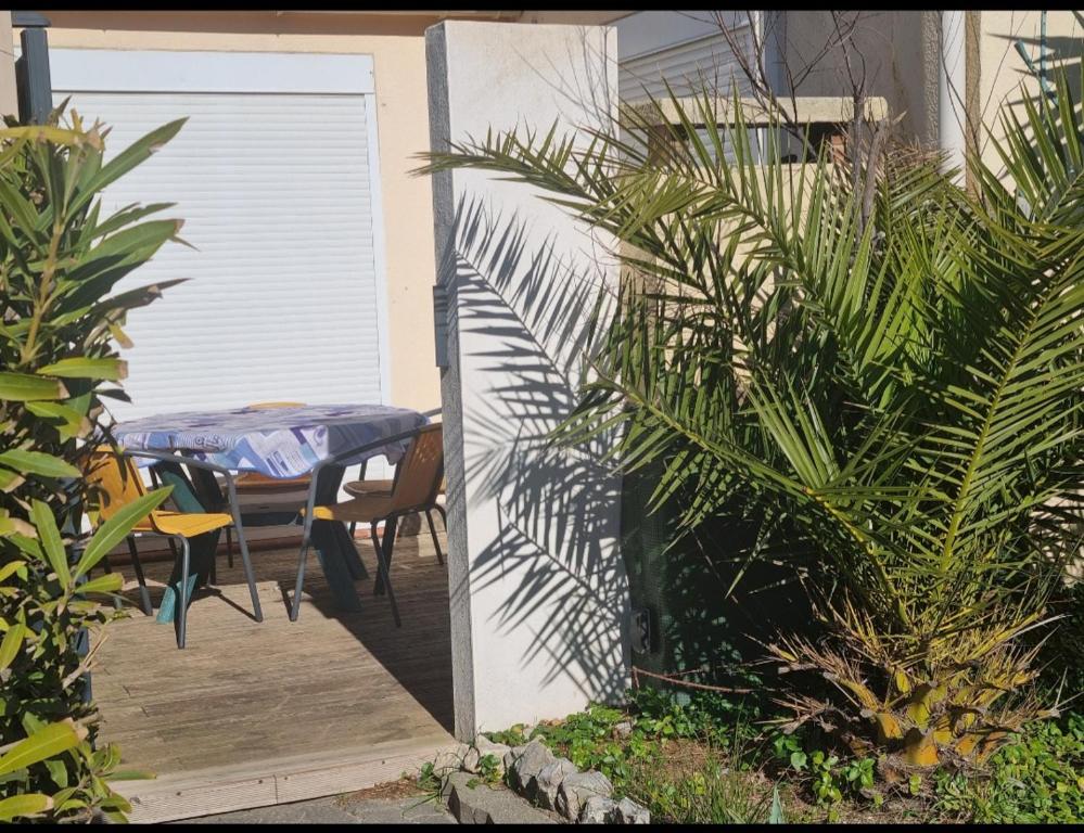 une porte menant à une terrasse avec une table. dans l'établissement 100m de la plage, jolie maison 5 personnes, CLIM, secteur Lydia Grande Plage, au Barcarès