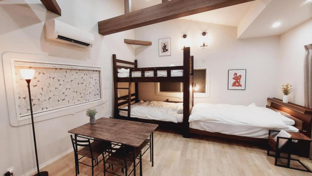 a bedroom with two bunk beds and a table at Hyuga Surf Camp 210 - Vacation STAY 35366v in Hyuga