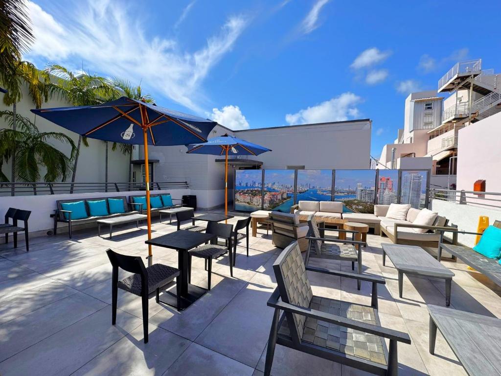 a patio with tables and chairs on a building at The Cove By Renzzi in Miami Beach