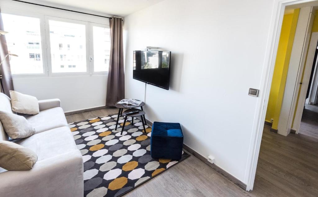 un salon avec un canapé et une télévision à écran plat dans l'établissement Cozy apartment - Montrouge, à Montrouge