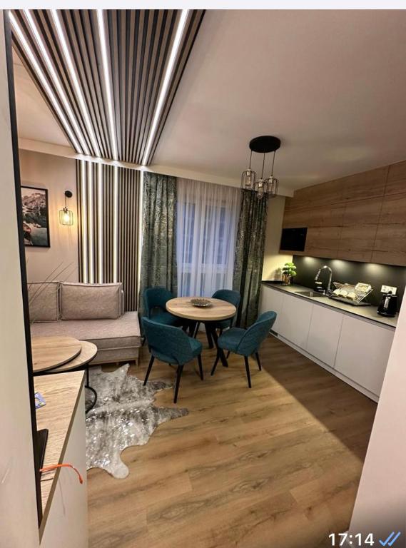 a living room with a couch and a table and a kitchen at JHM Apart in Zakopane