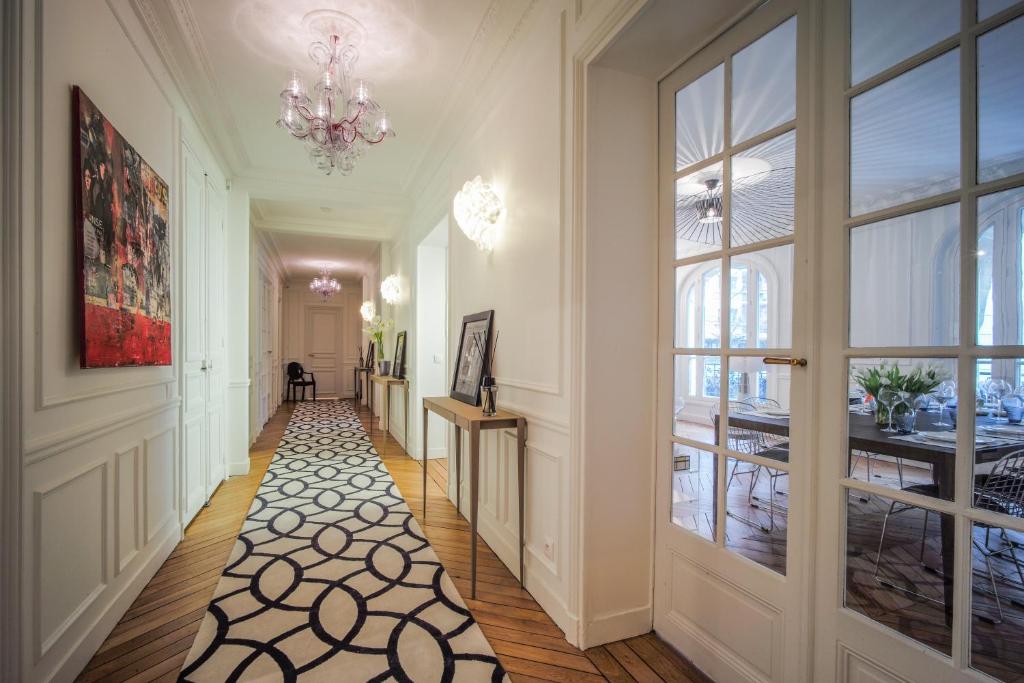 a hallway with a chandelier and a large window at Relais12bis Bed & Breakfast By Eiffel Tower in Paris