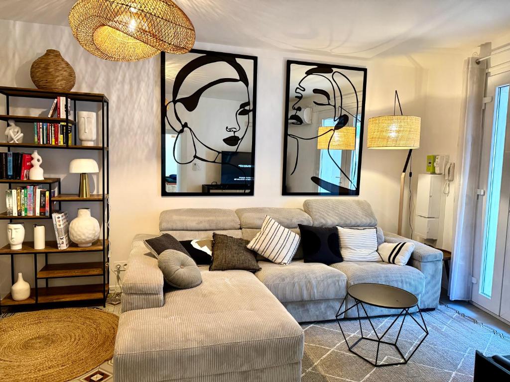 a living room with a couch and two pictures on the wall at Superbe appartement grande terrasse centre ville St Rémy in Saint-Rémy-de-Provence