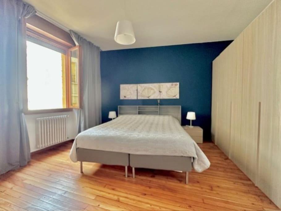 ein Schlafzimmer mit einem großen Bett mit einer blauen Wand in der Unterkunft Appartamento Vista Lago! in Gardone Riviera