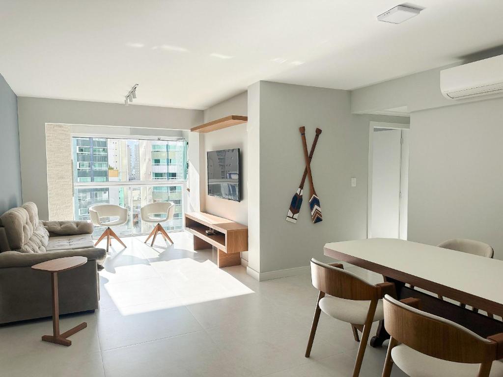 una sala de estar con una mesa y sillas en Turim, en Balneário Camboriú