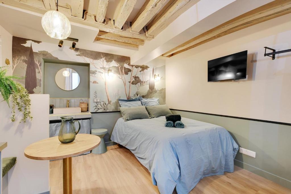 une chambre avec un lit, une table et une télévision dans l'établissement Cozy studio in Le Marais - fully equipped, à Paris