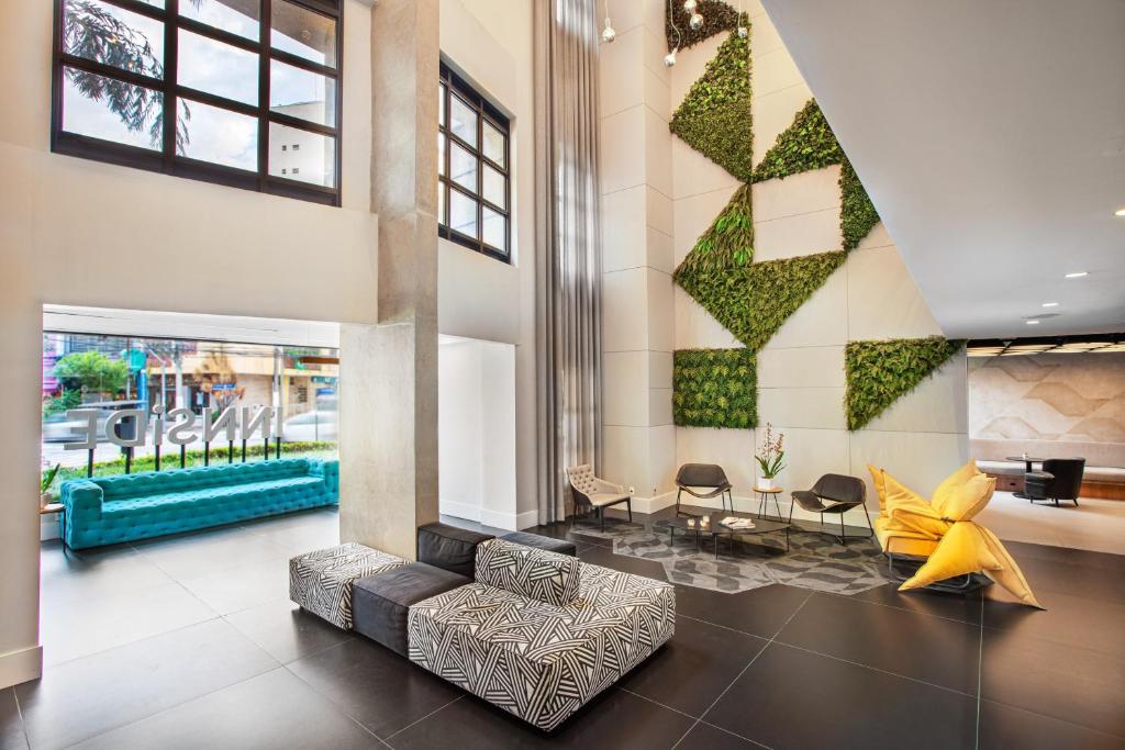 eine Lobby mit einem Sofa, einem Tisch und Stühlen in der Unterkunft INNSiDE by Meliá São Paulo ITAIM in São Paulo