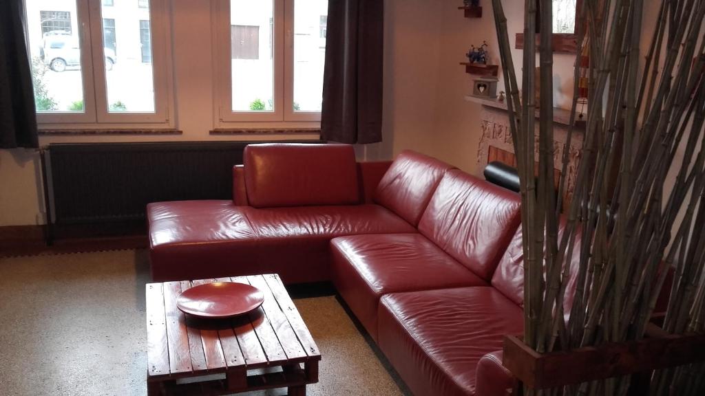 a living room with a brown leather couch and a table at La Coulemelle in Merlemont