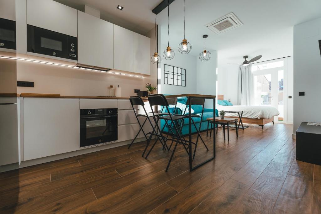 eine Küche und ein Esszimmer mit Tisch und Stühlen in der Unterkunft Macarena Suites in Cáceres