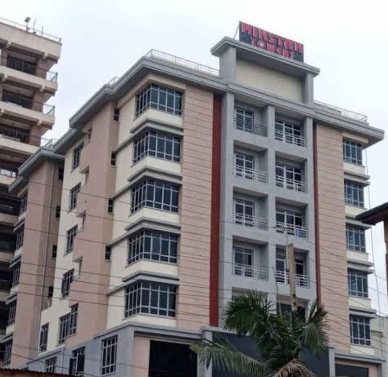 a tall building with a sign on top of it at Minstan towers in Nairobi