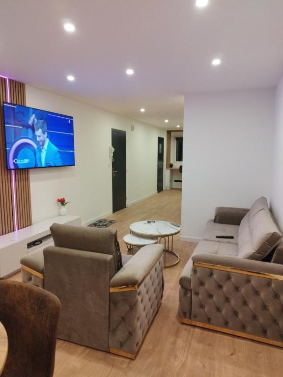 un salon avec un canapé et une télévision dans l'établissement Appartement Cosy, Nantes-St-Herblain, à Saint-Herblain