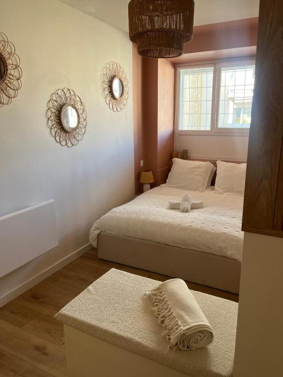 - une chambre avec 2 lits, une fenêtre et des miroirs dans l'établissement Escapade Méditerrannéenne Appart' Cosy et Élégant, à Toulon