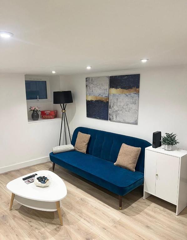 a living room with a blue couch and a table at Cosy 1 bedroom flat in London in London