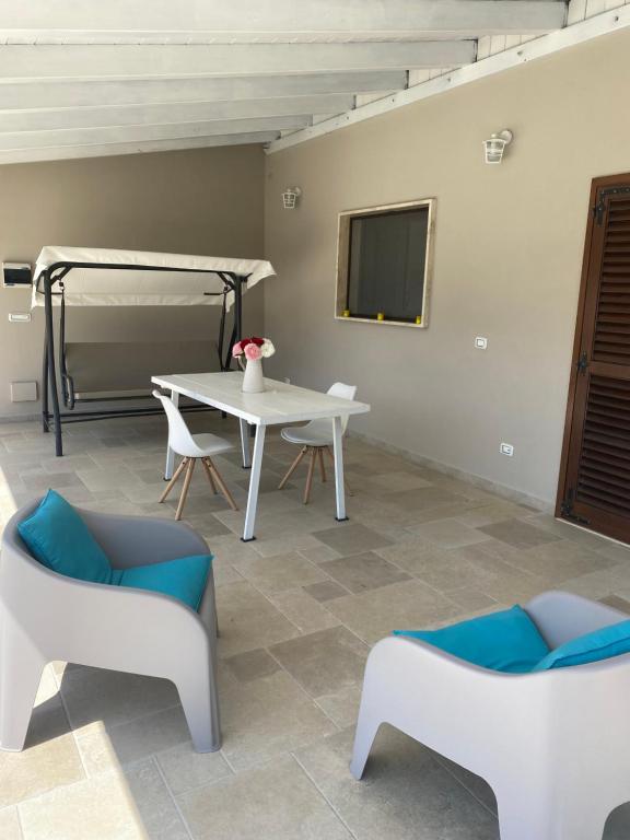 un salon avec une table et des chaises et un lit dans l'établissement Villa Leone Holiday House, à Latiano