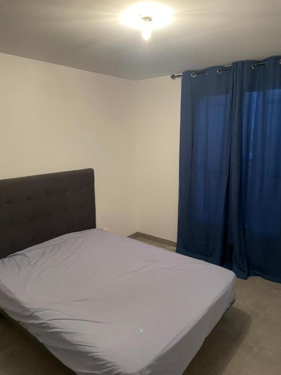 - une chambre avec un lit doté de rideaux bleus dans l'établissement Maison à louer Aubière 63, à Aubière