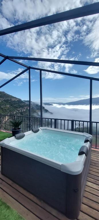 a hot tub on a deck with a view of the ocean at Cal Foraster in Estorm