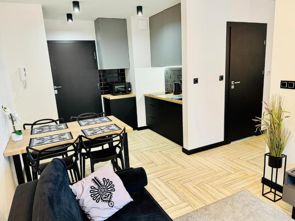 uma sala de estar com uma mesa e uma cozinha em Apartamenty Trimont nad Jeziorem Czorsztyńskim em Kluszkowce