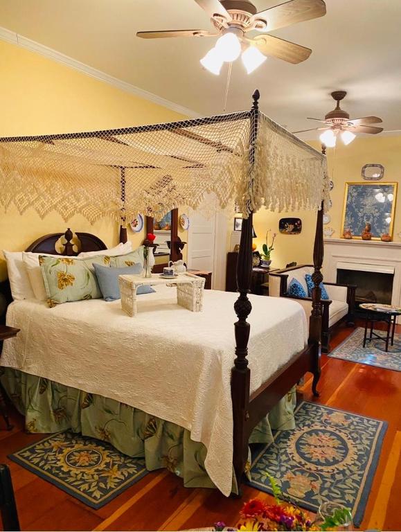 a bedroom with a canopy bed and a piano at Magnolia Cottage Bed and Breakfast in Natchez
