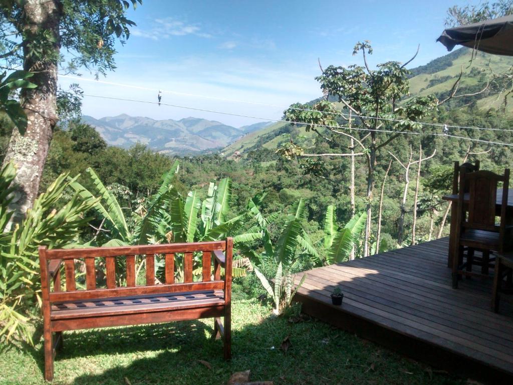 a wooden bench sitting on top of a wooden deck at Casinha Gostosa na Serra in São Francisco Xavier