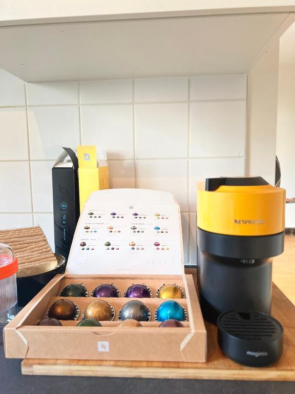 a box of chocolates sitting next to a coffee maker at Brussels-Hôtel-appartement in Brussels
