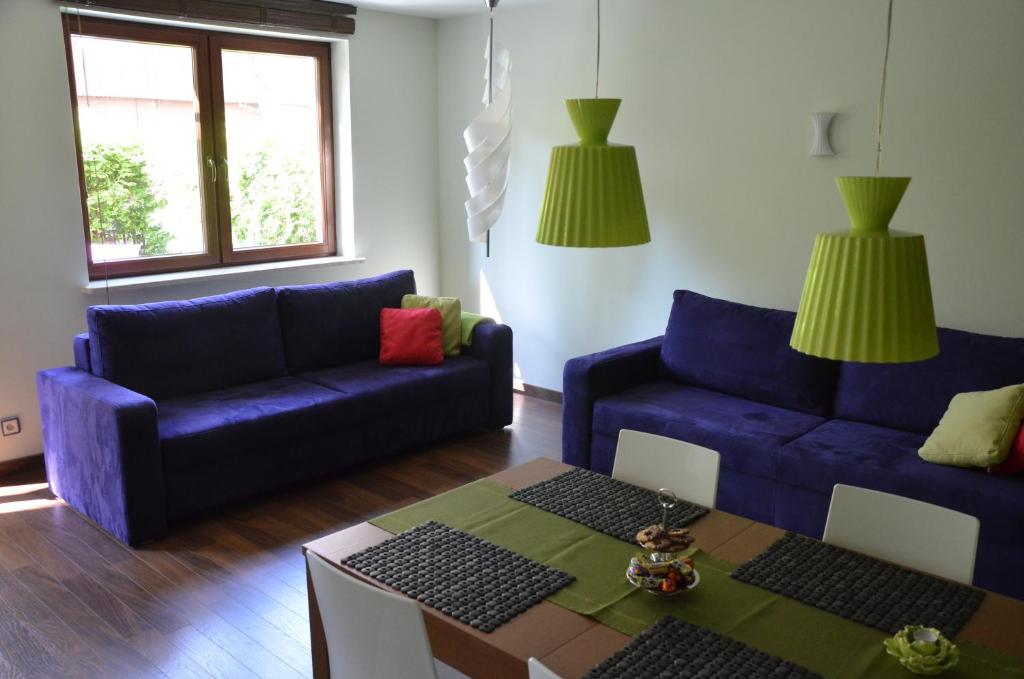 uma sala de estar com dois sofás azuis e uma mesa em Apartament Agata em Świnoujście