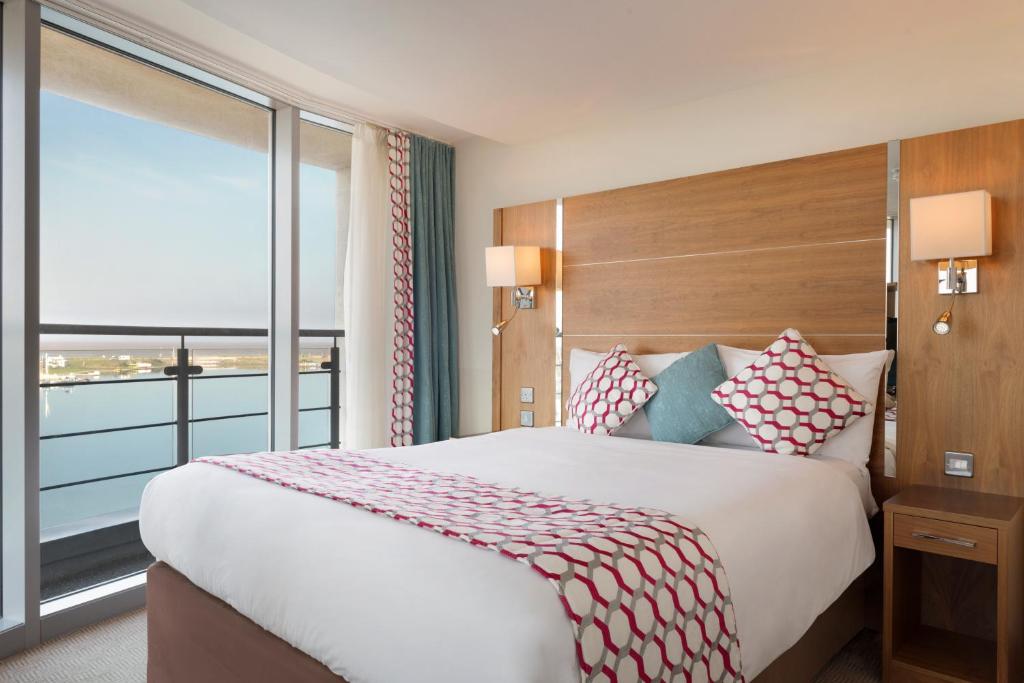 a bedroom with a large bed with a large window at Waterfront Southport Hotel in Southport