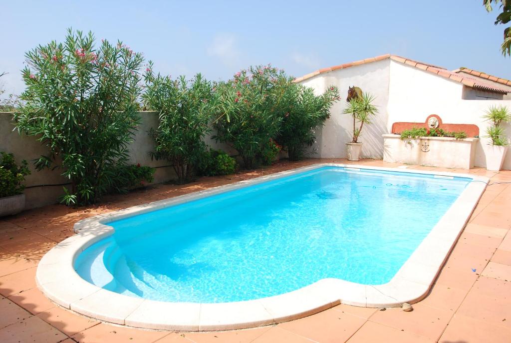 a swimming pool in the backyard of a house at Soleil De Camargue in Le Sambuc