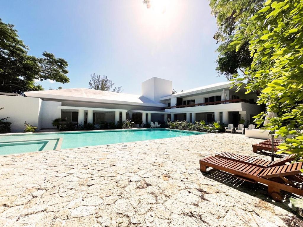 a swimming pool in front of a house at Beachside Tranquility Condo in Cozumel