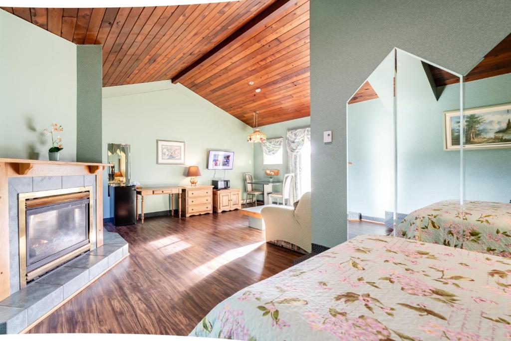 a room with a fireplace and a bedroom with a bed at Hotel Motel Bonsoir in Granby