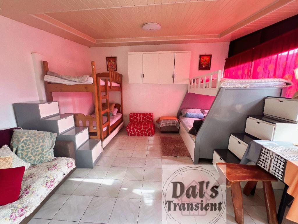 um quarto com paredes cor-de-rosa e beliches em Dal's Transient em Baguio