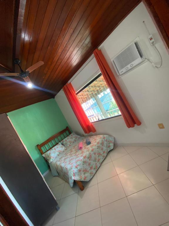 a small room with a bed and a window at Casa da Nataliana in Cabo Frio