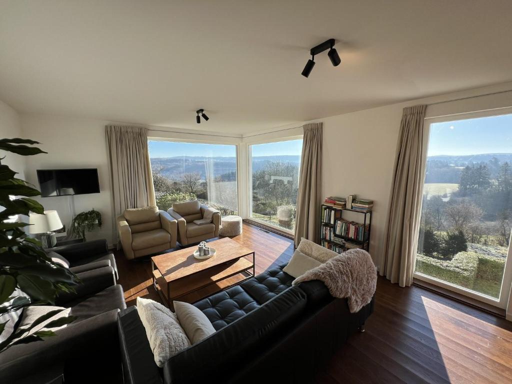 a living room with a couch and a table at Panoramic villa with private sauna in Érezée