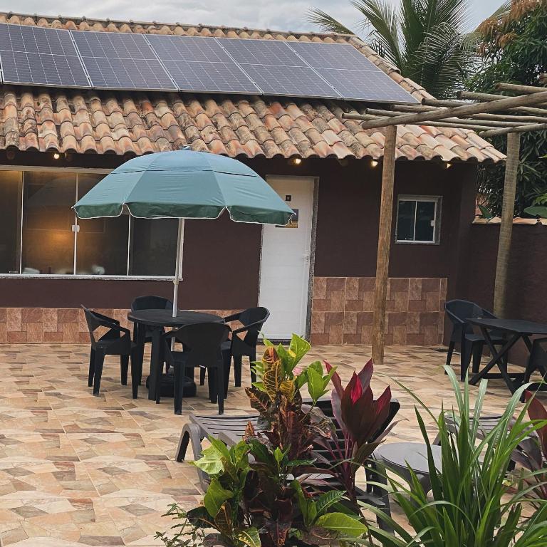 a patio with a table and chairs and an umbrella at Casa do João in Maricá