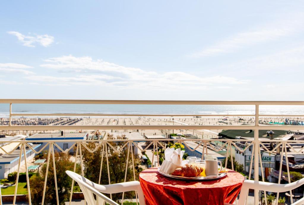 una mesa con plato de comida y vistas a la playa en Hotel Lungomare, en Cervia
