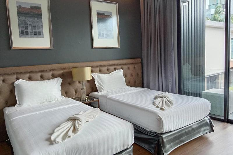 een hotelkamer met twee bedden en een raam bij villa kamala regent 2 bedrooms in Kamala Beach