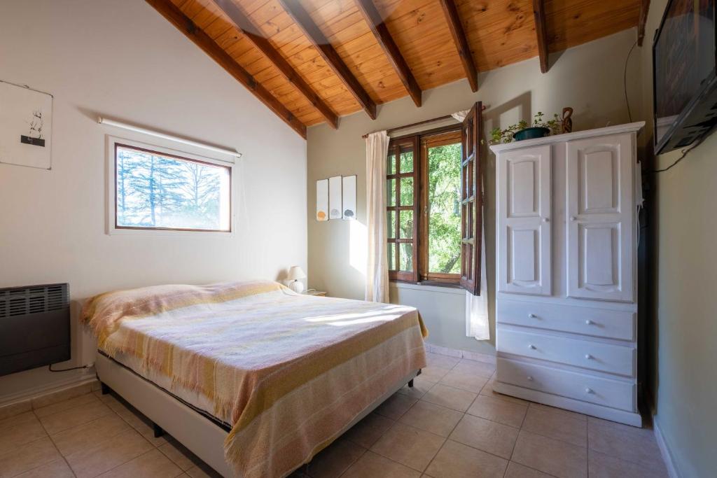 ein Schlafzimmer mit einem Bett und einem Fenster in der Unterkunft Grace in Villa General Belgrano