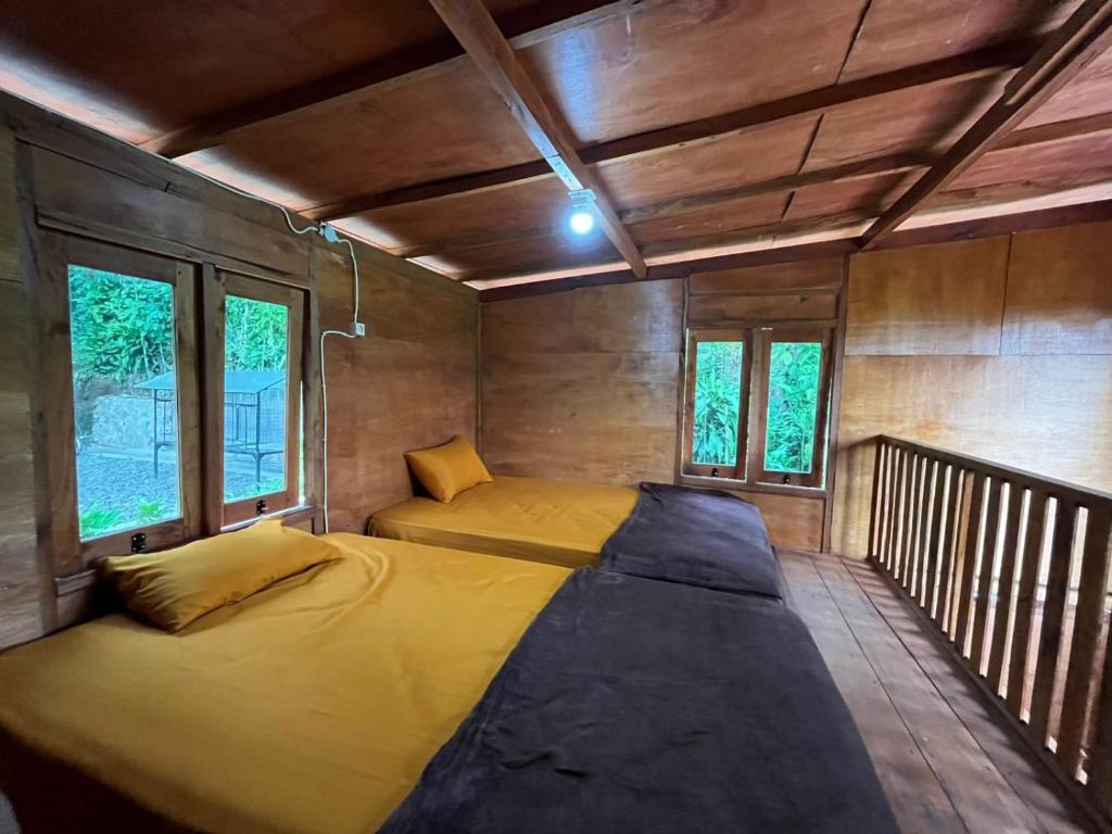 Un dormitorio con una cama grande en una habitación con ventanas. en The Valley house cidwi resort, en Cicadas