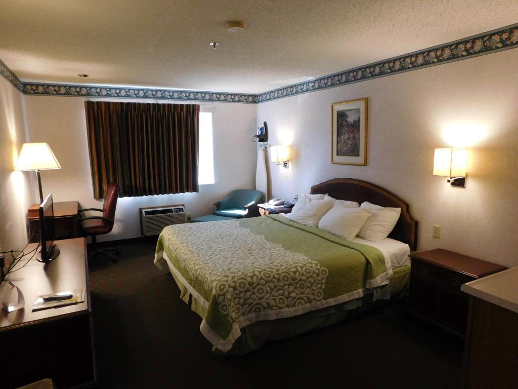 a hotel room with a bed and a television at Days Inn by Wyndham Lexington NE in Lexington